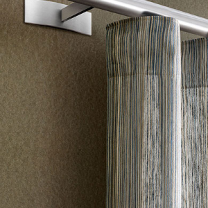 Eine silberne Vorhangstange an einer braunen Wand