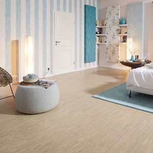 Ein Schlafzimmer mit hellen Wänden und Korkboden