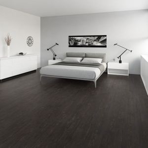 Ein Schlafzimmer mit weißen Wänden und dunklem Laminatboden
