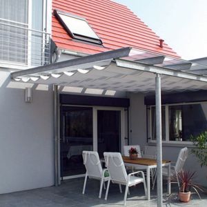 Ein weißes Massivhaus mit einer Terrasse und Gartenmöbel