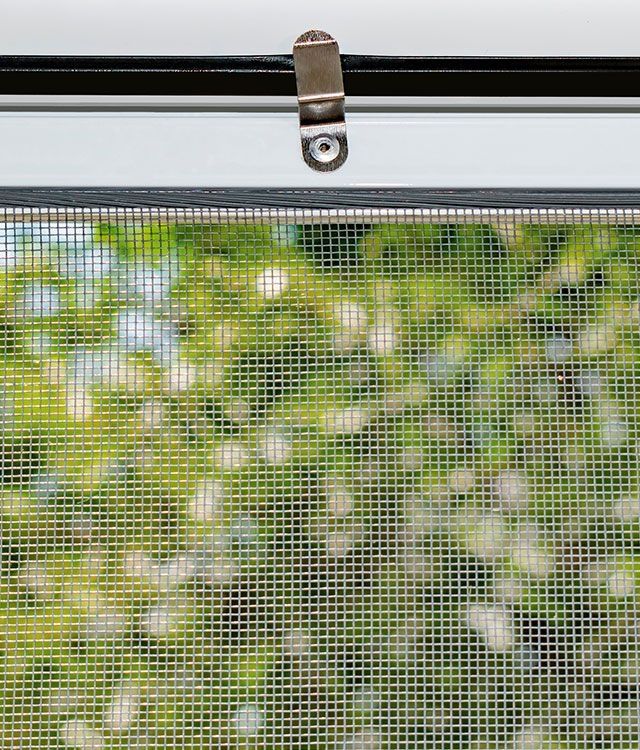 Eine Nahaufnahme von einem Fenster mit Insektenschutz