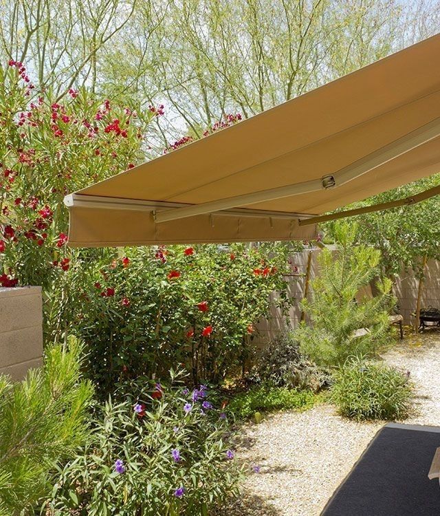 Einen gelbe Markise in einem grünem Garten