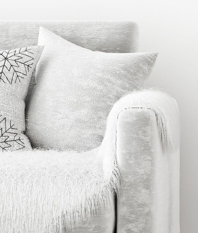 Ein weißes Sofa mit weißen Kissen und weißer Decke