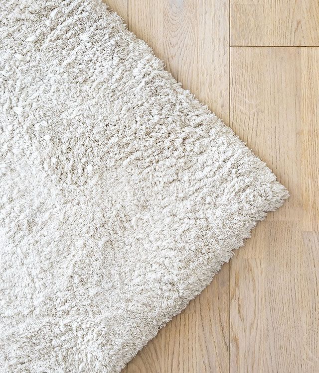 Ein weißer Teppich auf Holzboden